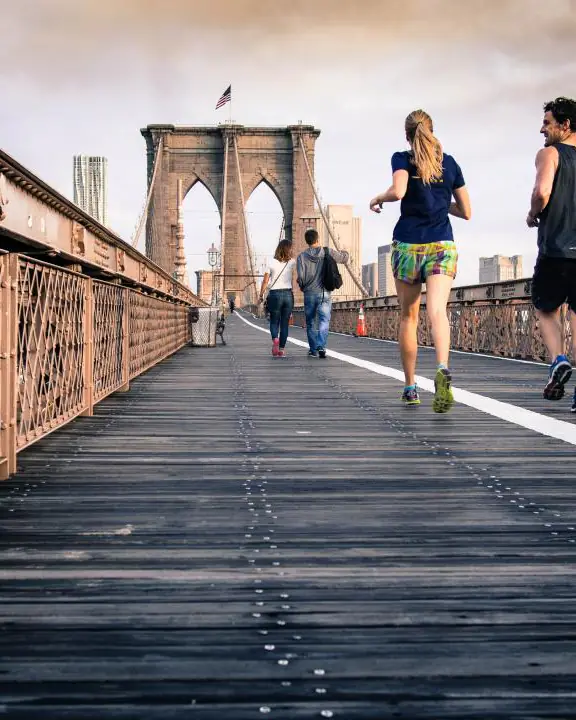 People running across a bridge in fresh morning air