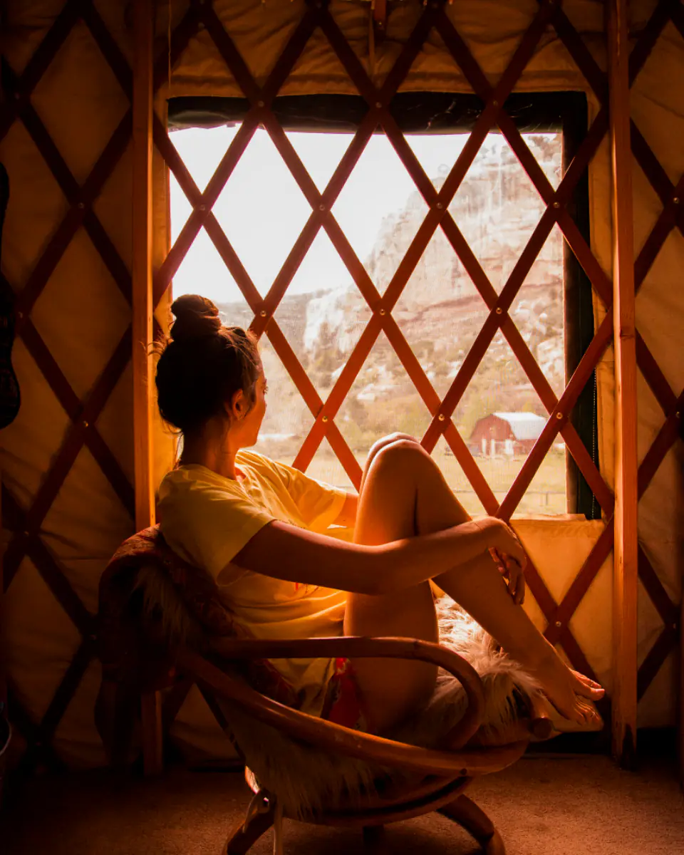 A woman sitting peacefully in a sunlit window