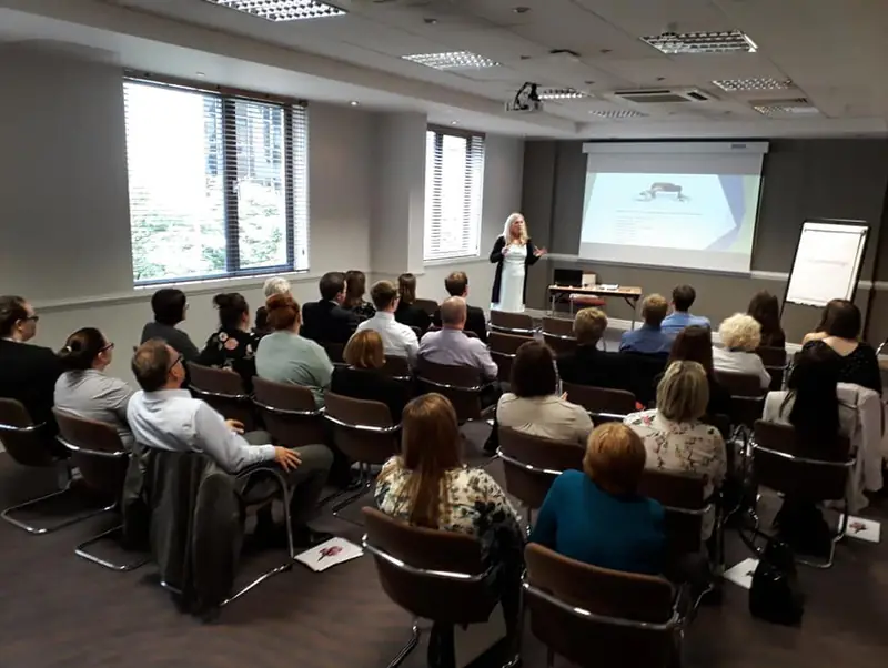 Sonya Hudson presenting to a full conference room